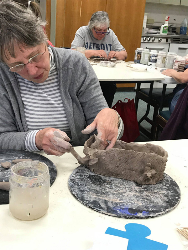 Adults working on ceramic sculpture
