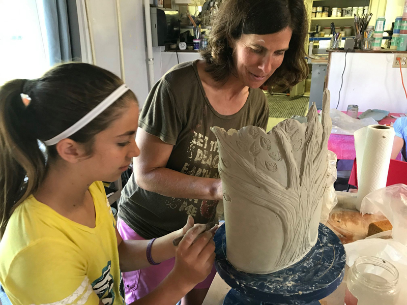 mother and daughter creating a ceramic vase in family pottery class
